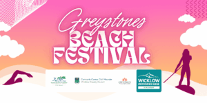 Promotional banner for the Greystones Beach Festival. The background features a vibrant pink-to-orange sunset gradient with stylized clouds and waves. Silhouettes of a swimmer and a stand-up paddleboarder flank the central, stylized text reading "Greystones Beach Festival." A white sponsor bar at the bottom features logos for Wicklow Sports & Recreation Partnership, Wicklow County Council, Greystones Wellness Hub, and the teal Wicklow Outdoors Week logo with the dates 10–16 August.