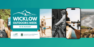 Digital banner for Wicklow Outdoors Week, running 10–16 August. The left side features a prominent teal block containing the mountain outline logo and event dates, with the Wicklow Sports & Recreation Partnership and Wicklow County Council logos directly underneath. The rest of the banner displays a horizontal carousel showcasing outdoor activities: hiking, beach volleyball, mountain biking, kayaking (displayed inside a smartphone frame mock-up), and a scenic view of the Wicklow coastline.